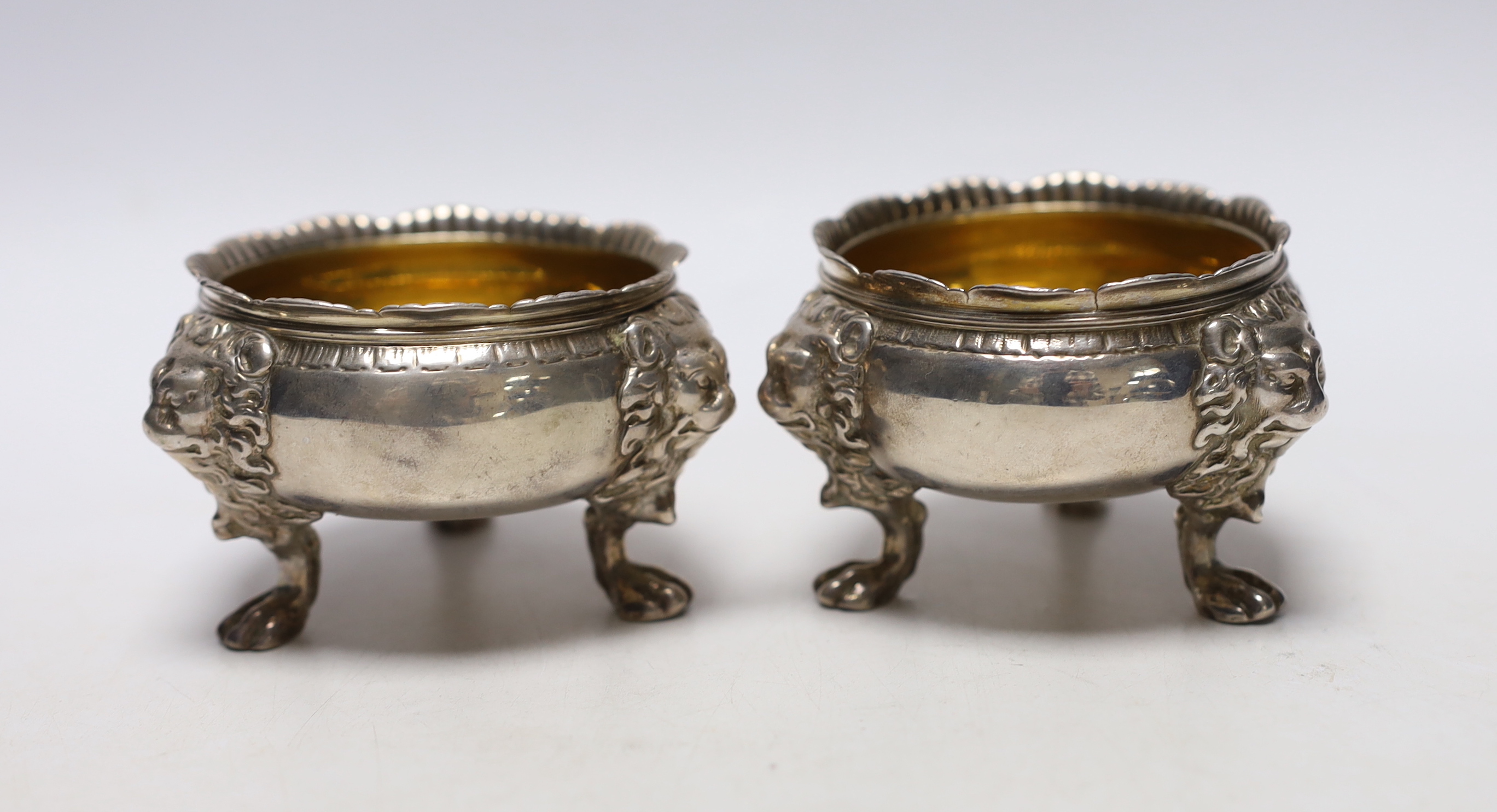 A pair of George II silver bun salts, with lion mask knees, on paw feet, maker's mark rubbed, London, 1736, diameter 70mm, 11.9oz.